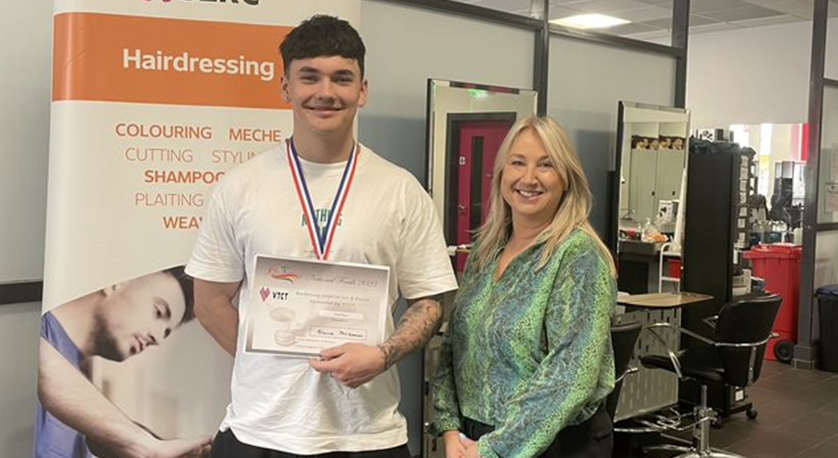 Level 3 Barbering student Blaine McKeown holding his AHT competition certificate with his tutor Sarah-June Robinson